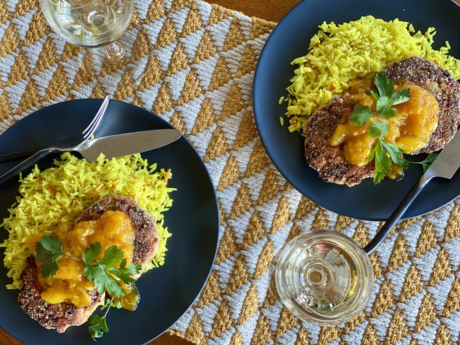 Curried slamon cakes, mango chutney, and coconut rice served on two plates