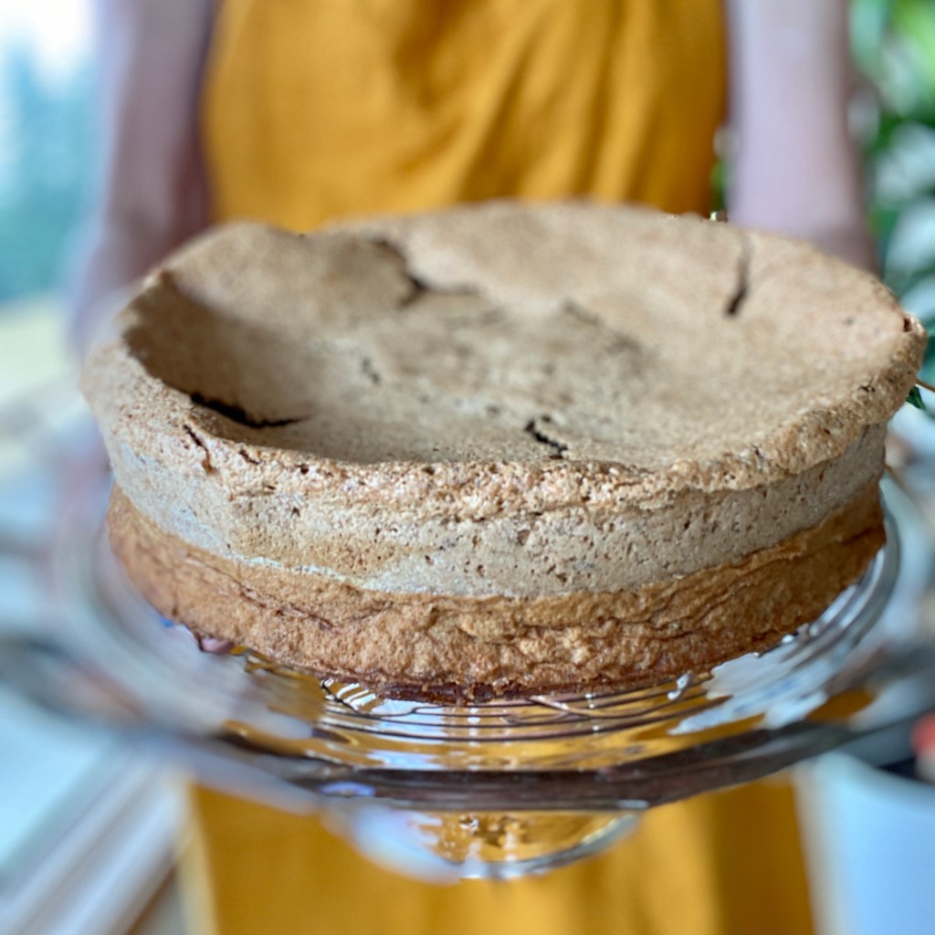Woman holding place with flourless walnut cake. 
