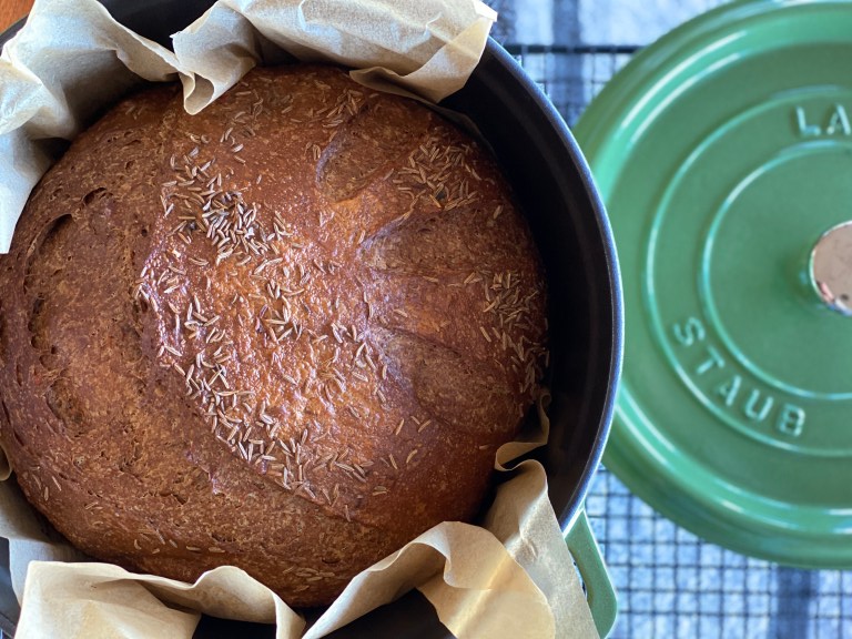 A loaf of caraway rye black bread in its Staub baking pot.