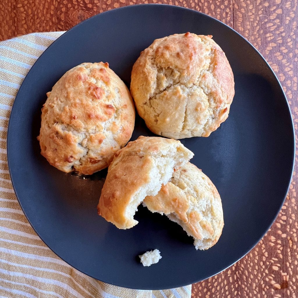 A plateful of three olive oil biscuits, one with a bite taken out.
