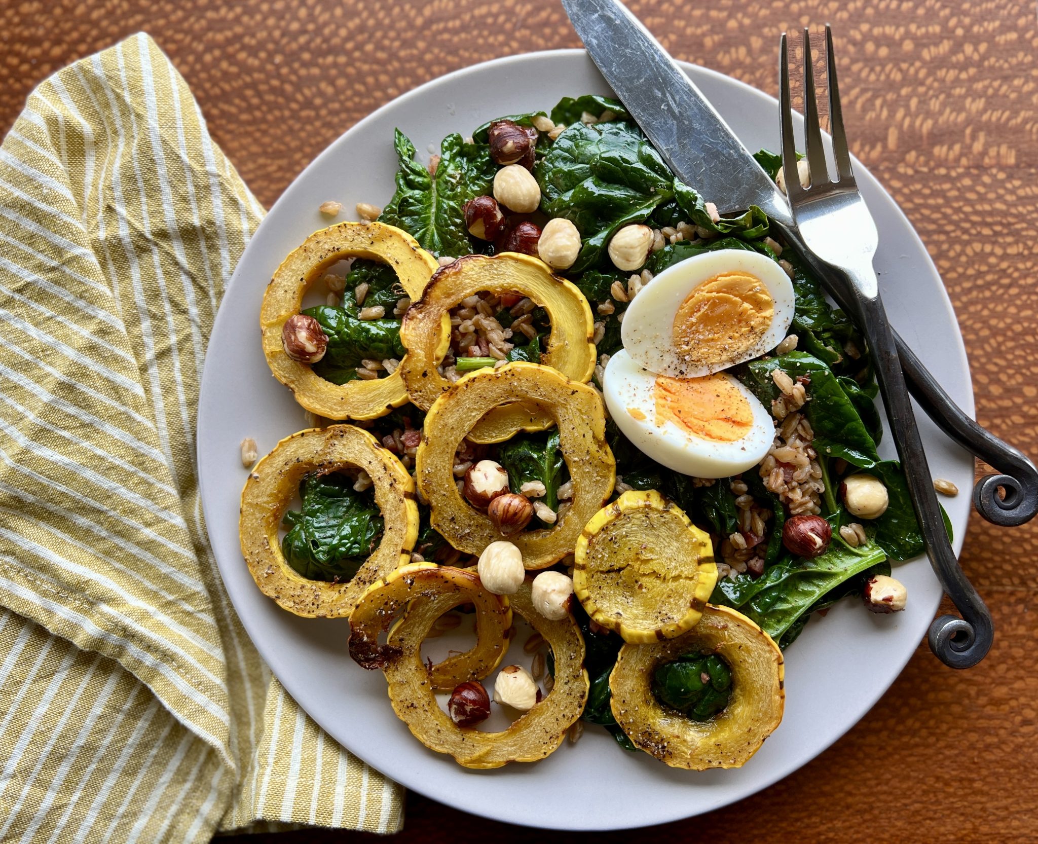A plate of spinach salad and pancetta vinaigrette