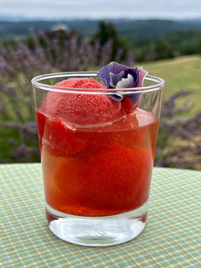 Raspberry and Rosé cocktail with mountains in the background.