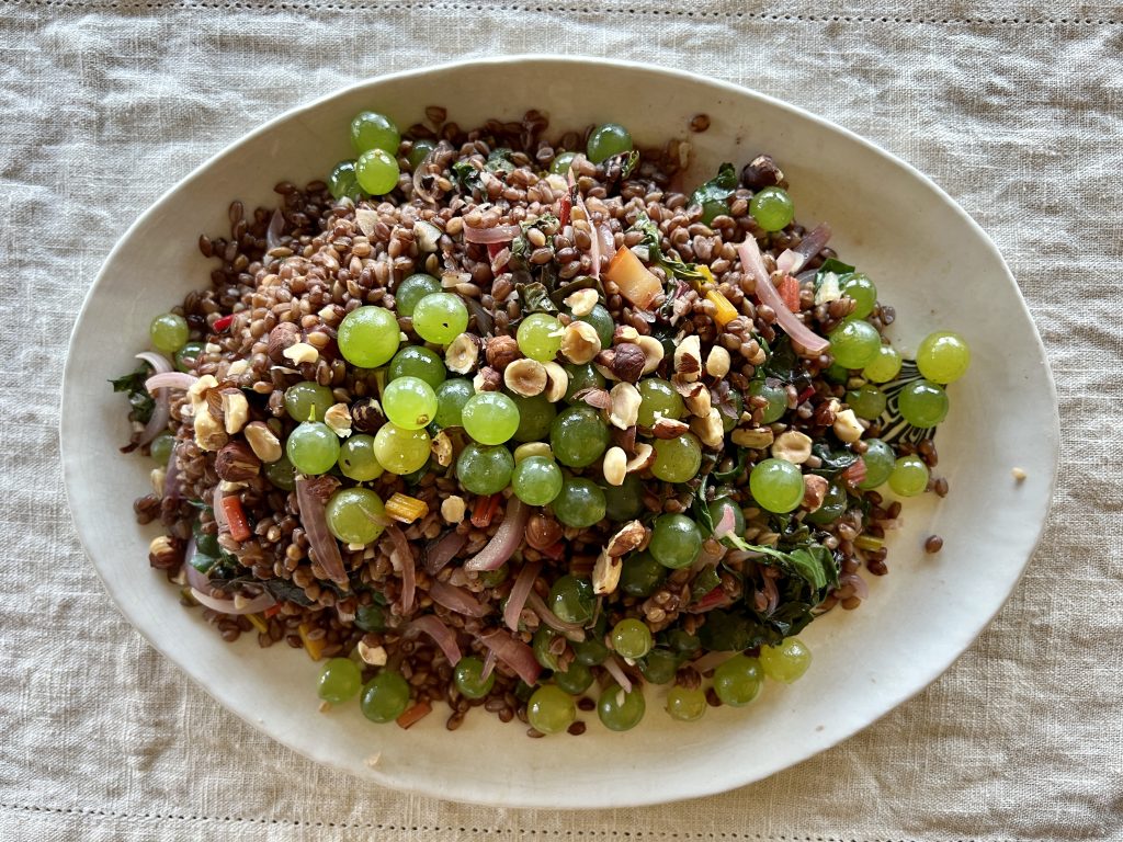 A platter of grains, grapes, and greens pilaf