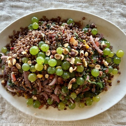 A platter of grains, grapes, and greens pilaf