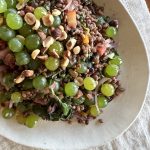 a platter of warm grains, grapes, and greens pilaf